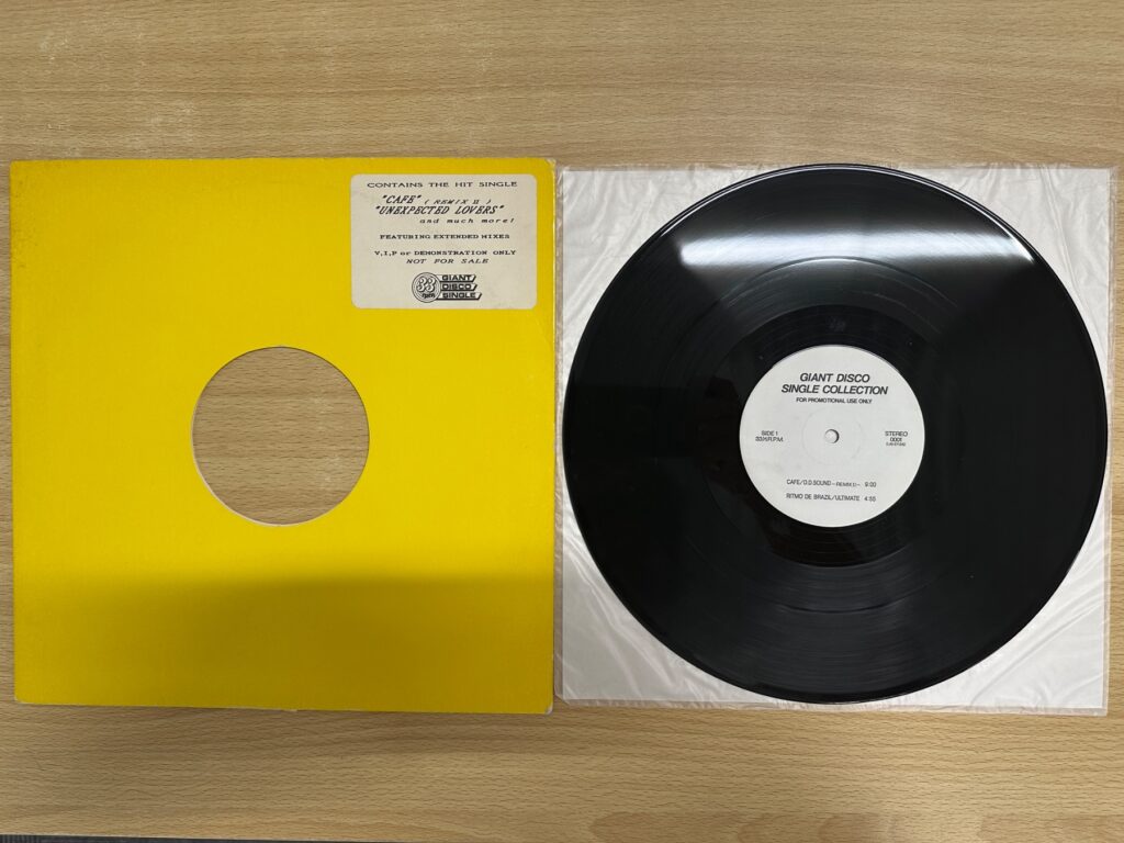 プロモ盤のレコードと黄色いジャケット、盤面のラベルが見える