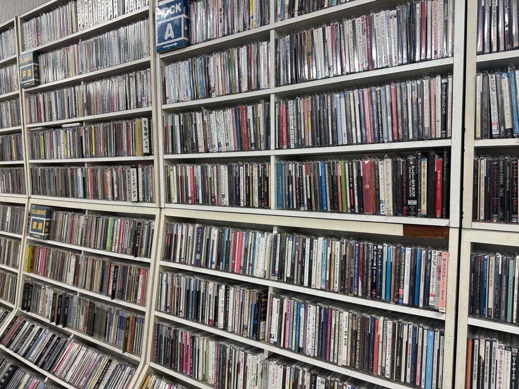 レコードショップの棚にCDやDVDがぎっしり並ぶ店内の在庫