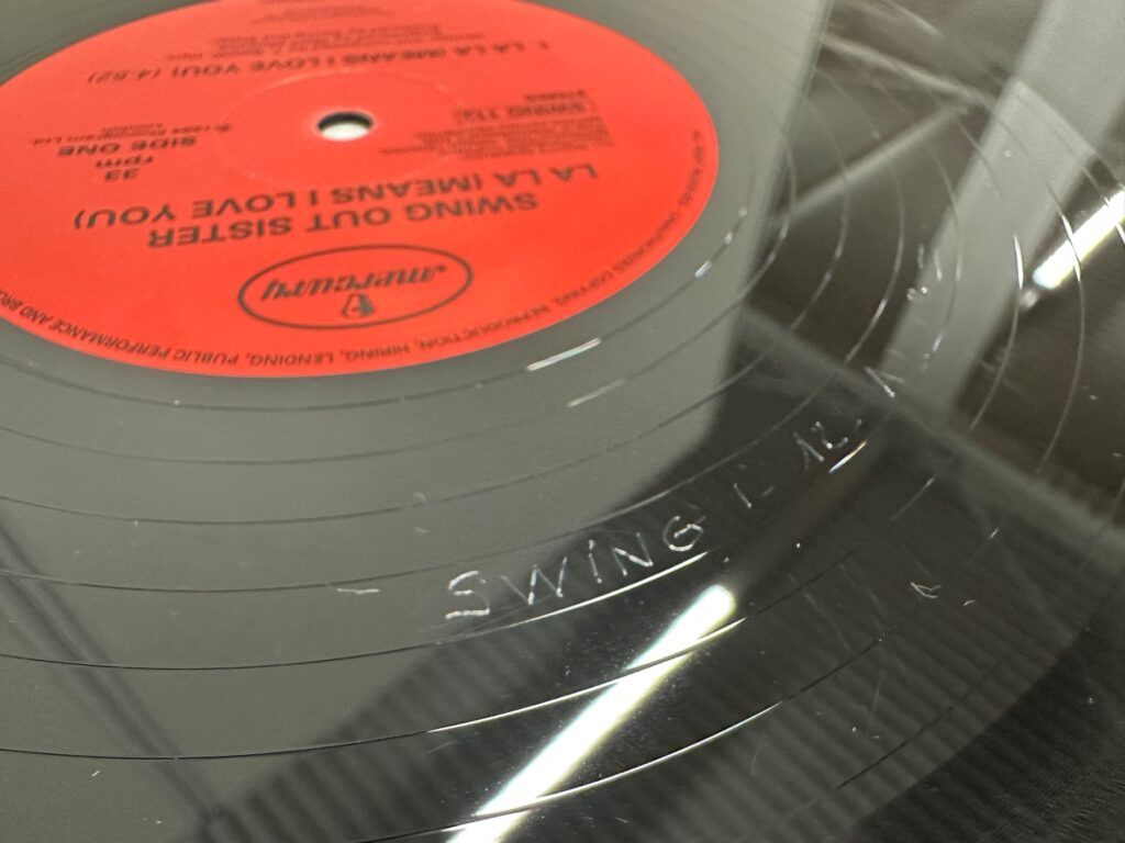 ターンテーブルに載せた、赤いレーベルの12インチレコード「LA LA MEANS I LOVE YOU」