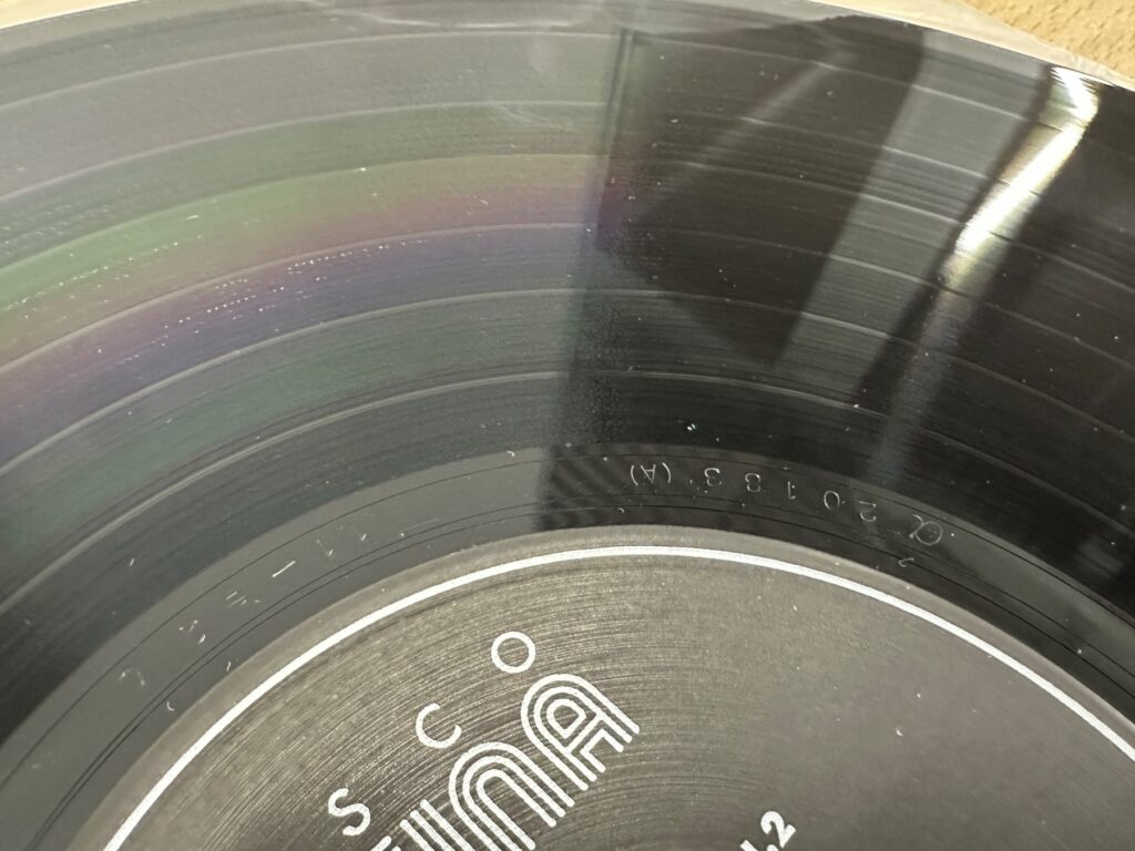 中古LPレコードの盤面を拡大した写真。溝に細かな擦れやほこりが見える。