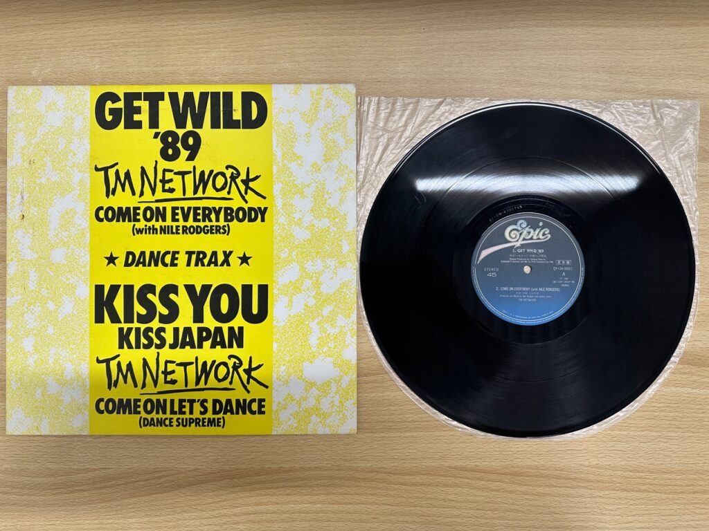 TM NETWORK『DANCE TRAX』のジャケットと黒いアナログ盤。ジャケットに「GET WILD ’89」などの曲名が記載されている。
