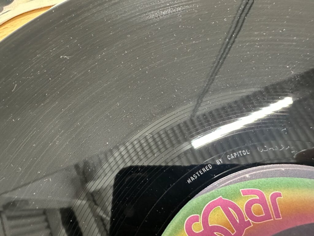 傷やスレ、ほこりが目立つレコード盤面のクローズアップ画像