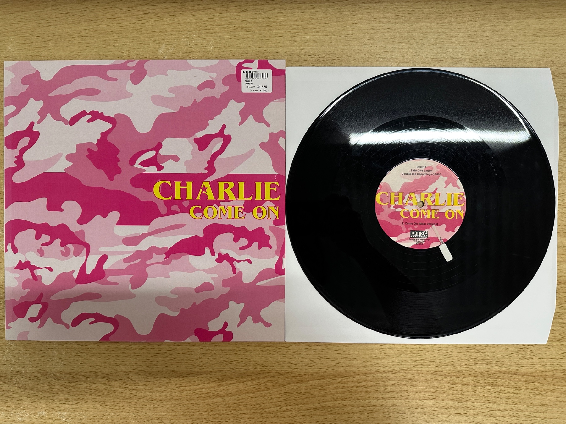 ピンクの迷彩柄ジャケットと、Charlie「Come On」の盤面に擦り傷がある黒いアナログレコードを並べた写真